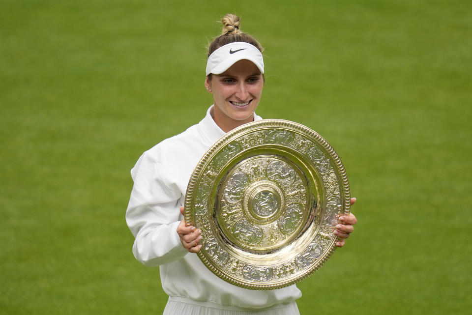 Czech Republic's Marketa Vondrousova celebrates with the trophy after beating Tunisia's Ons Jabeur to win the final of the women's singles on day thirteen of the Wimbledon tennis championships in London, Saturday, July 15, 2023. (AP Photo/Kirsty Wigglesworth)