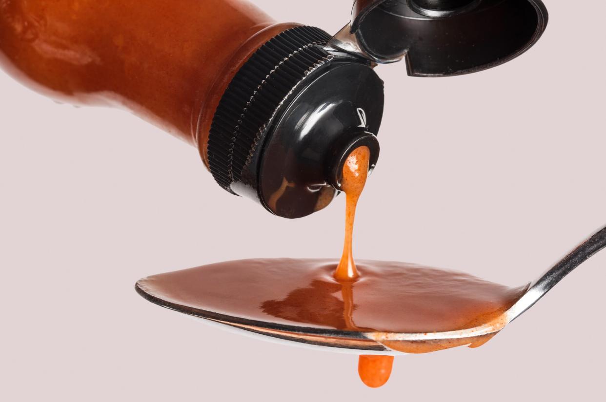 hot sauce being poured on a spoon