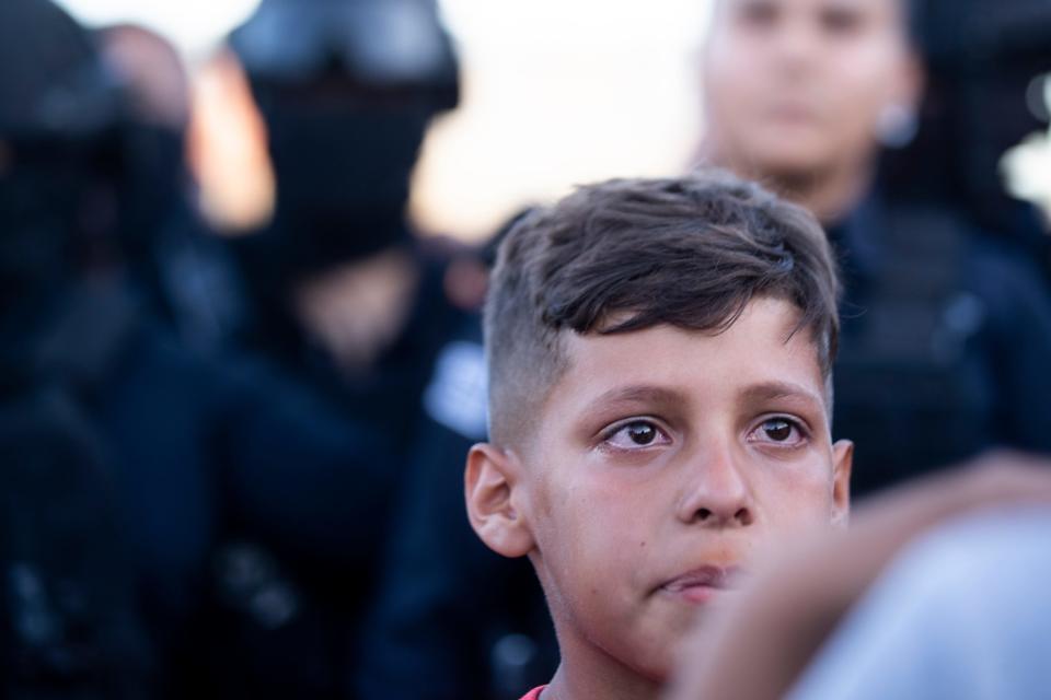 A young migrant cries after Ciudad Juarez municipal police take his familyÕs tent on Monday, May 22, 2023. The migrants had camped in front of a migrant facility where 40 migrants died as a result of a fire on March 27, 2023. 