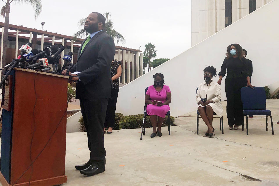 Compton, Calif., City Attorney Damon Brown, left, with Mayor Aja Brown, standing right, calls on the state attorney general's office and the U.S. Department of Justice to investigate the Los Angeles County Sheriff's station at a news conference in Compton Tuesday, Aug. 4, 2020. A violent gang of sheriff's deputies who call themselves "The Executioners" control a patrol station in Compton through force, threats, work slowdowns and acts of revenge against those who speak out, a deputy alleged in a legal claim. (AP Photo/Stefanie Dazio)