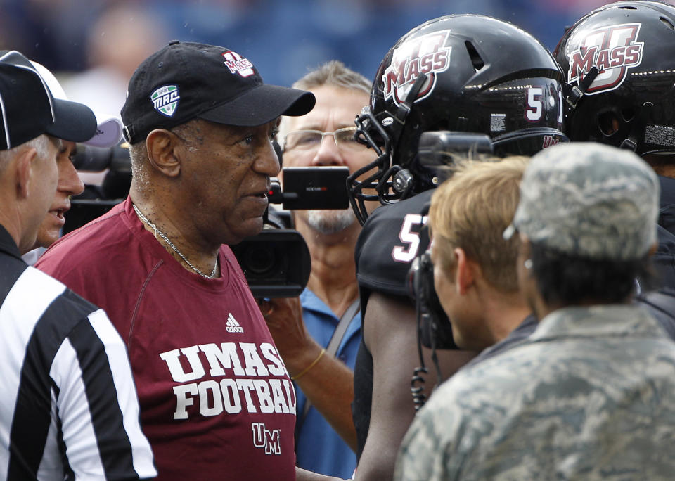 Comedian and University of Massachusetts graduate Bill Cosby huddles with members of the Massachusetts team during the coin toss before their NCAA college football game against Indiana in Foxborough, Mass., Saturday, Sept. 8, 2012. (AP Photo/Stephan Savoia)