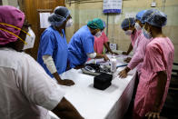 Hospital staff goes through the documents prior to COVID-19 vaccination drive at a hospital in Kolkata, India, Saturday, Jan. 16, 2021. India started inoculating health workers Saturday in what is likely the world's largest COVID-19 vaccination campaign, joining the ranks of wealthier nations where the effort is already well underway. (AP Photo/Bikas Das)