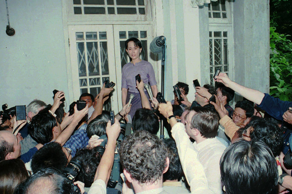 FILE - Burmese pro-democracy leader Aung San Suu Kyi is surrounded by reporters at her home on the first day of her release from house arrest in Rangoon on July 11, 1995. Myanmar court on Monday, Dec. 6, 2021, sentenced ousted leader Suu Kyi to 4 years for incitement and breaking virus restrictions, then later in the day state TV announced that the country's military leader reduced the sentence by two years. (AP Photo/Stuart Isett, File)