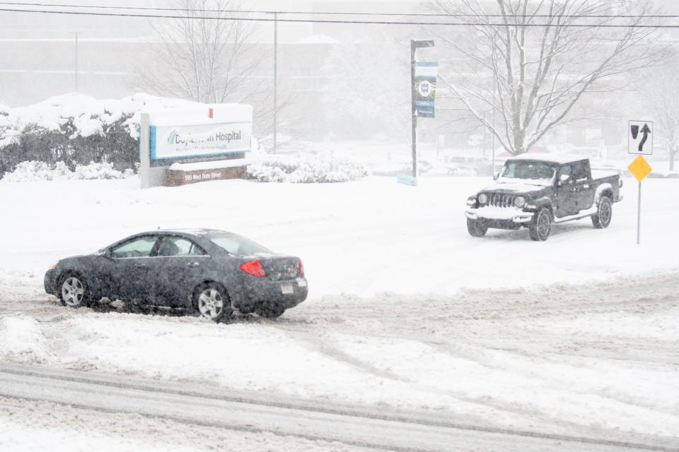 A car drives past Doylestown Hospital during a snow storm Tuesday, February, 13, 2024.