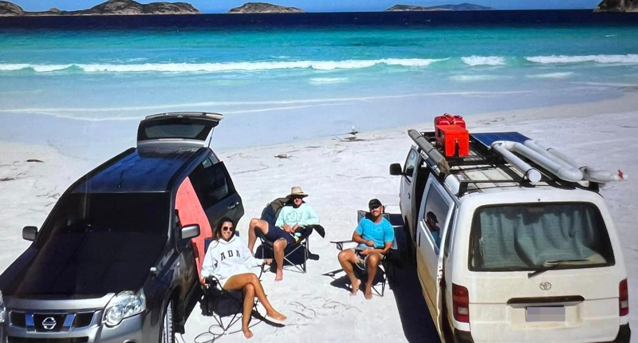 Three people pictured flying a drone on a West Australian beach.