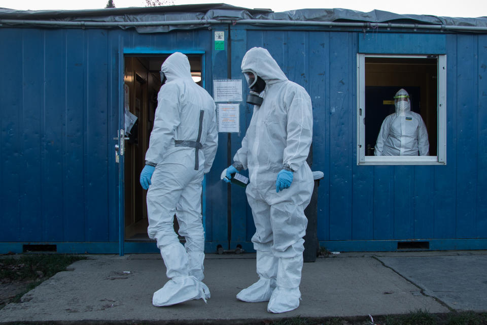 Doctors in hazmat suits at a testing facility. 