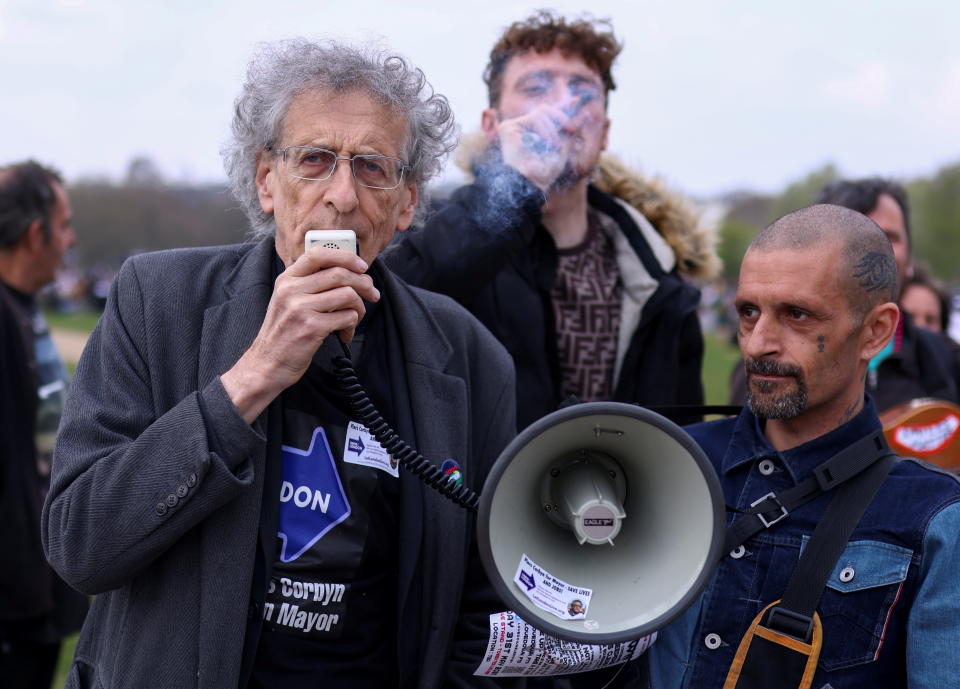 Piers Corbyn, candidate for Mayor of London and brother of former Labour Party leader Jeremy Corbyn, speaks through a megaphone, as a man smokes behind him, during a demonstration in Hyde Park to mark the informal cannabis holiday, 4/20, in London, Britain, April 20, 2021. REUTERS/Tom Nicholson