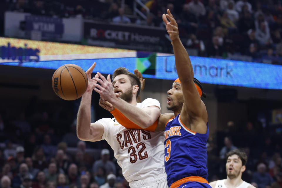 Cleveland Cavaliers forward Dean Wade (32) and New York Knicks guard Josh Hart (3) vie for a rebound during the first half of an NBA basketball game Friday, March 31, 2023, in Cleveland. (AP Photo/Ron Schwane)