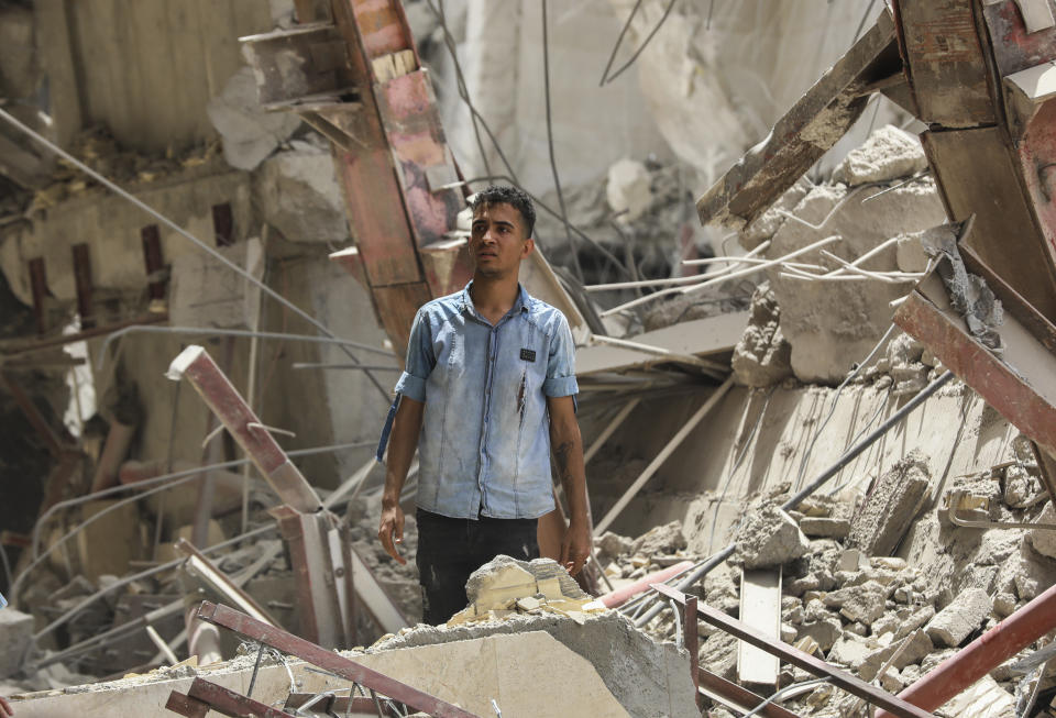 In this photo provided by Tasnim News Agency, a man stands amid the ruins of an under construction 10-story commercial building that collapsed killing several people, in the southwestern city of Abadan, Iran, Monday, May 23, 2022. There are fears the casualty toll could be much higher as more than 80 people were still believed to be trapped under the rubble after the Metropol building toppled, burying shops and even some cars in the surrounding streets, state TV reported. (Hossein Abdollah Asl, Tasnim News Agency via AP)