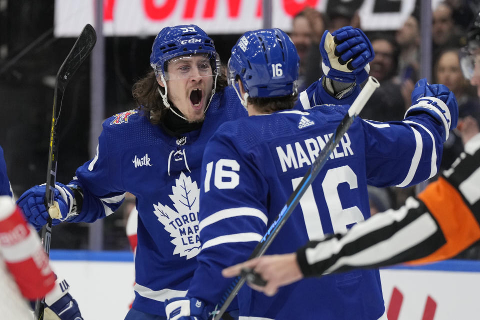 Toronto Maple Leafs right wing Mitchell Marner (16) celebrates after his goal with teammate Tyler Bertuzzi, left, during second-period NHL hockey game action against the Detroit Red Wings in Toronto, Sunday, Jan. 14, 2024. (Frank Gunn/The Canadian Press via AP)