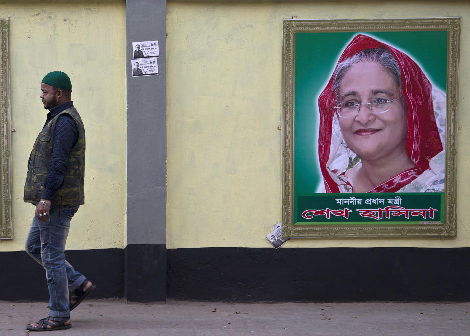 A man walks past a portrait of Bangladesh Prime Minister Sheikh Hasina on the eve of general elections in Dhaka, Bangladesh, Saturday, Dec. 29, 2018. As Bangladeshis get set for Sunday's parliamentary elections, there are fears that violence and intimidation could keep many away from the polls, including two opposition candidates who said police had barricaded them inside their homes. (AP Photo/Anupam Nath)