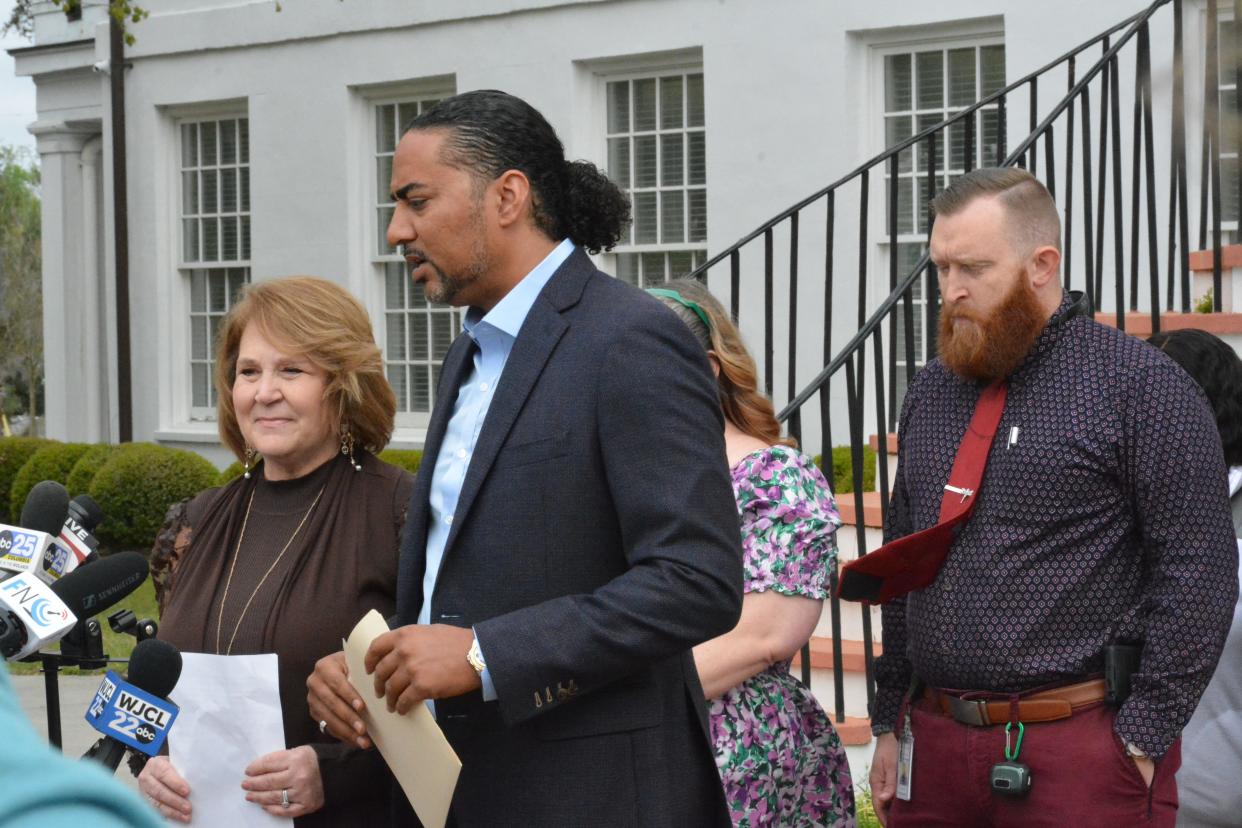 Colleton County Clerk of Court Rebecca Hill, at left, is flanked by attorney Justin Bamberg as she announces her resignation from office Monday morning in Walterboro.