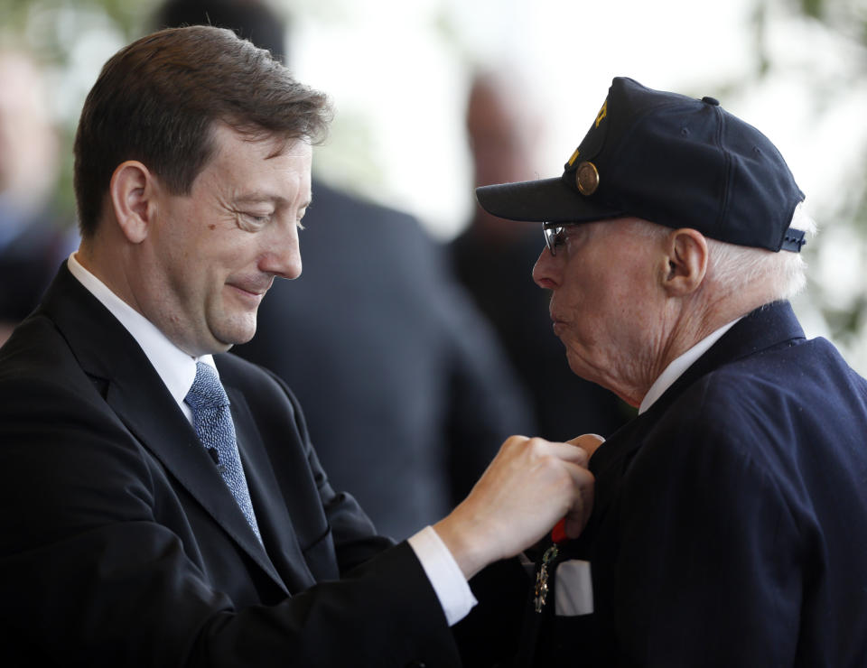 Consul General of France in New York Bertrand Lortholary, left, presents an insignia of the French Legion of Honor to World War II veteran Robert Fraissinet of Malverne, N.Y., during a ceremony at the U.S. Military Academy on Friday, May 9, 2014, in West Point, N.Y. Thirty-four veterans were honored 70 years after of the D-Day landings. (AP Photo/Mike Groll)