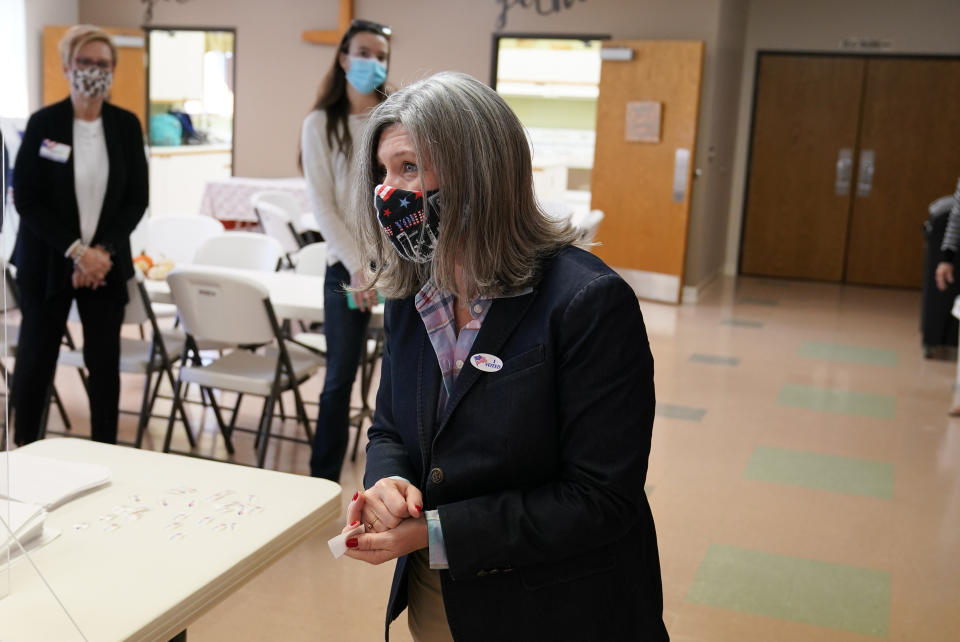 Republican Senate candidate Sen. Joni Ernst, center, talks to poll workers after casting her ballot at Red Oak First Christian Church Tuesday, Nov. 3, 2020, in Red Oak, Iowa. (AP Photo/Charlie Neibergall)