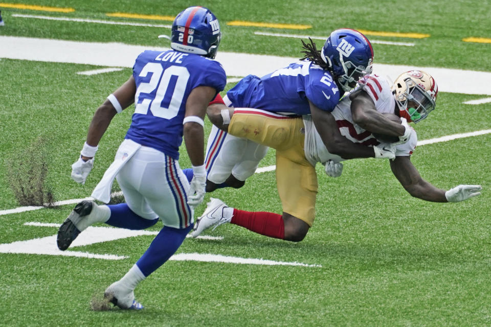 New York Giants' Isaac Yiadom, center, brings down San Francisco 49ers' Jerick McKinnon during the first half of an NFL football game, Sunday, Sept. 27, 2020, in East Rutherford, N.J. (AP Photo/Corey Sipkin)