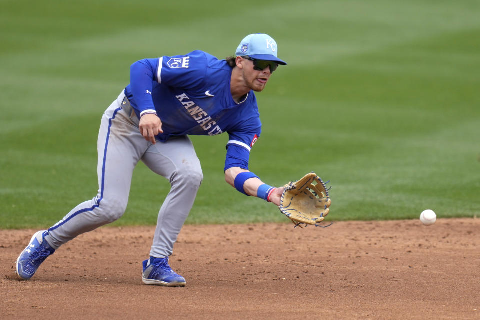 Kansas City Royals shortstop Bobby Witt Jr. fields a grounder hit by Colorado Rockies' Sean Bouchard before throwing to first base for the out during the third inning of a spring training baseball game Tuesday, March 12, 2024, in Scottsdale, Ariz. (AP Photo/Ross D. Franklin)