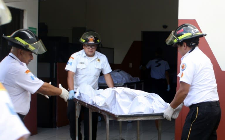 Guatemalan firefighters carry the corpse of one of the victims of a fatal blaze at a children's shelter in San Jose Pinula, on March 8, 2017