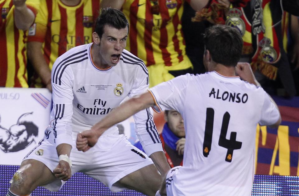 Real's Gareth Bale, left celebrates with Xabi Alonso after scoring his team's 2nd goal during the final of the Copa del Rey between FC Barcelona and Real Madrid at the Mestalla stadium in Valencia, Spain, Wednesday, April 16, 2014. (AP Photo/Alberto Saiz)