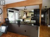 <p>The kitchen has granite countertops with an eating bar, and doors that open to the deck with a hot tub. </p>