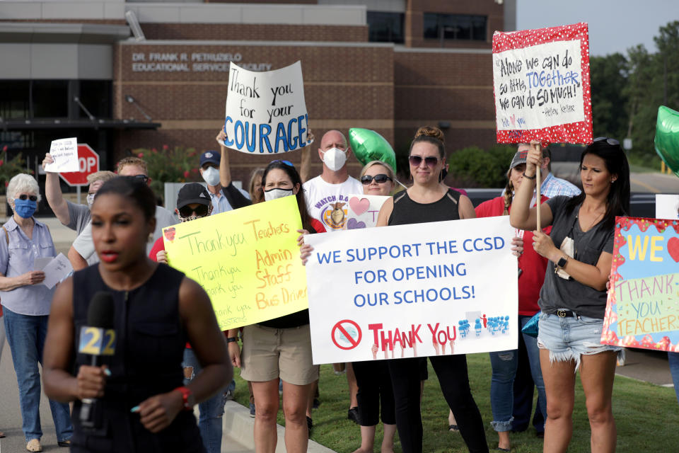 A TV news reporter filmed in front of supporters of reopening the Cherokee County School District — where a spike in cases caused the schools to close again, until at least Aug. 31. (Dustin Chambers/Reuters)