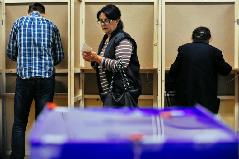 A woman prepares her ballot during parliamentary elections at a polling station in Podgorica on October 16, 2016