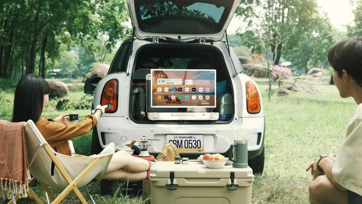  A screen contained in a briefcase on display in the back of a car whilst people eat. 