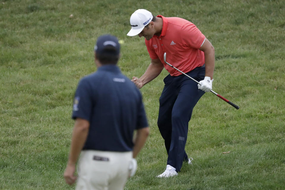 Jon Rahm, of Spain, right, celebrates after chipping for birdie on the 16th hole as Ryan Palmer watches during the final round of the Memorial golf tournament, Sunday, July 19, 2020, in Dublin, Ohio. (AP Photo/Darron Cummings)