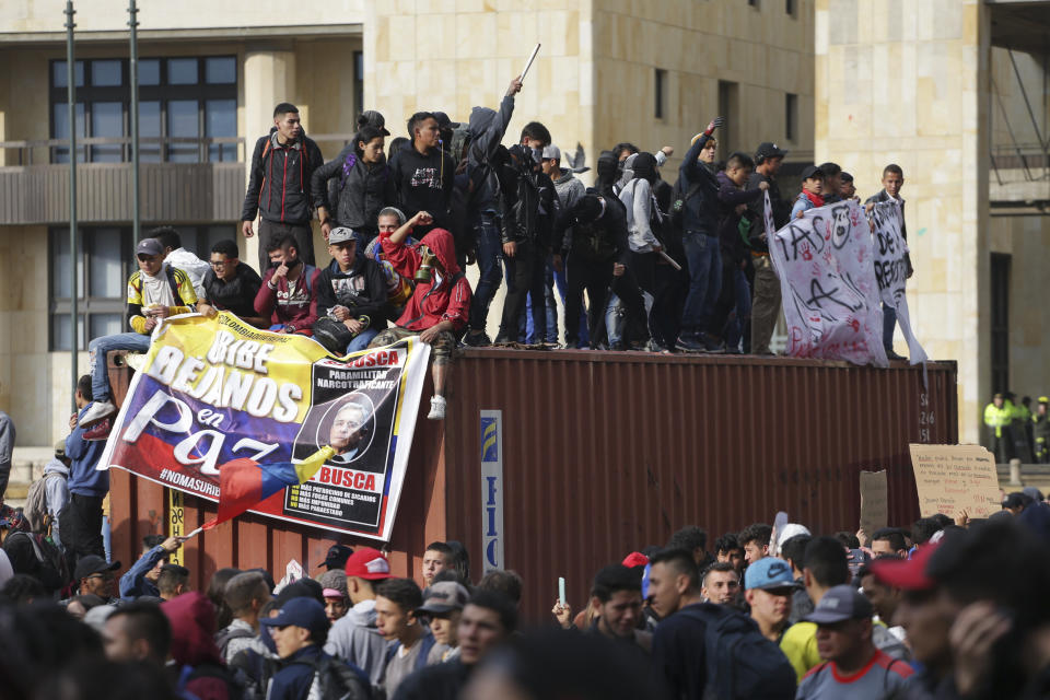 Anti-government protesters rally at the Bolivar square in Bogota, Colombia, Friday, Nov. 22, 2019. Colombian President Iván Duque ordered a curfew in the nation's capital amid continuing unrest one day after tens of thousands of people took to the streets in demonstrations during a nationwide strike. (AP Photo/Ivan Valencia)