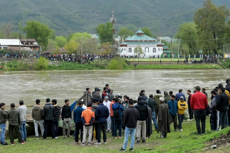 Des habitants se rassemblent sur les berges de la rivière où un bateau a fait naufrage à Srinagar en Inde, le 16 avril 2024 (-)