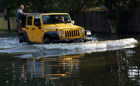 A family in a car return to their home for the first time since Harvey floodwaters arrived in north western Houston, Texas August 31, 2017. REUTERS/Rick Wilking