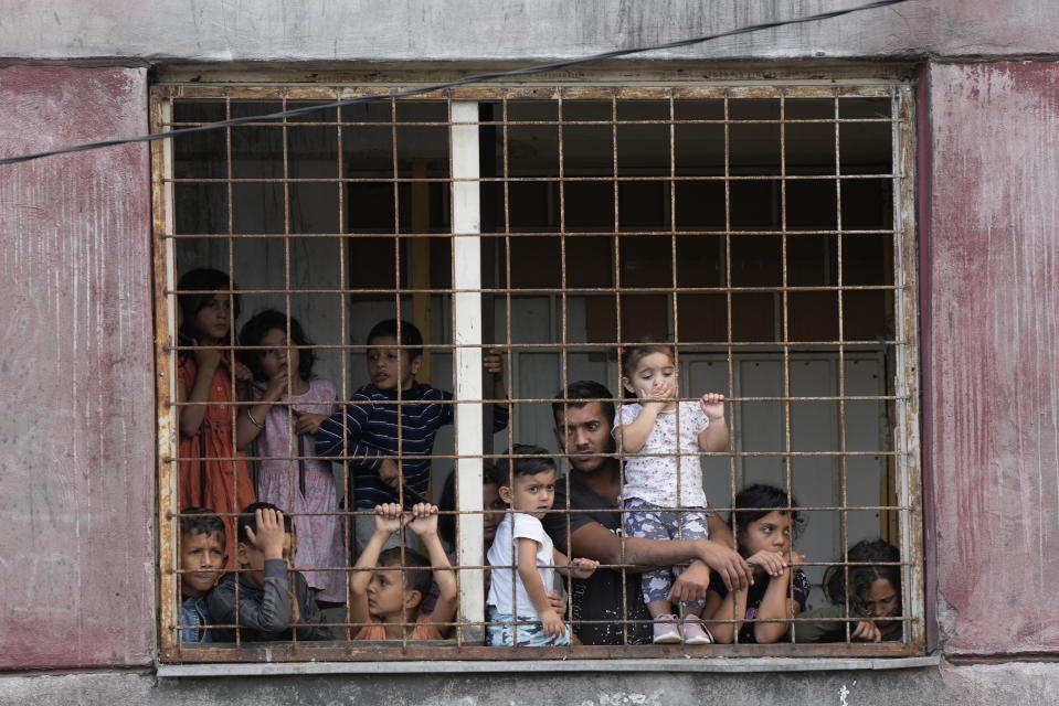 Residents watch Pope Francis meeting with members of the Roma community at Lunik IX, in Kosice, Slovakia, Tuesday, Sept. 14, 2021, the biggest of about 600 shabby, segregated settlements where the poorest 20% of Slovakia's 400,000 Roma live. Pope Francis traveled to Kosice, in the far east of Slovakia on Tuesday to meet with the country's Roma in a gesture of inclusion for the most socially excluded minority group in Slovakia, who have long suffered discrimination, marginalization and poverty. (AP Photo/Gregorio Borgia)