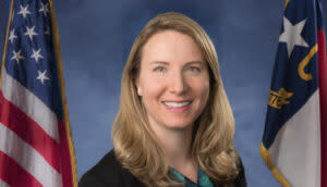 A headshot of Laura Hogshead, director of ReBuild NC. She is a white woman who appears to be in her early 40s, with shoulder-length blond hair. She is smiling.