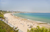 Enjoy seven miles of golden sands and some of the UK's warmest sea temperatures at this much-loved spot. While it might get busy during the sunny season, tourists come from afar to enjoy this bustling beach which is perfect for families and water sports enthusiasts alike. [Photo: Getty]