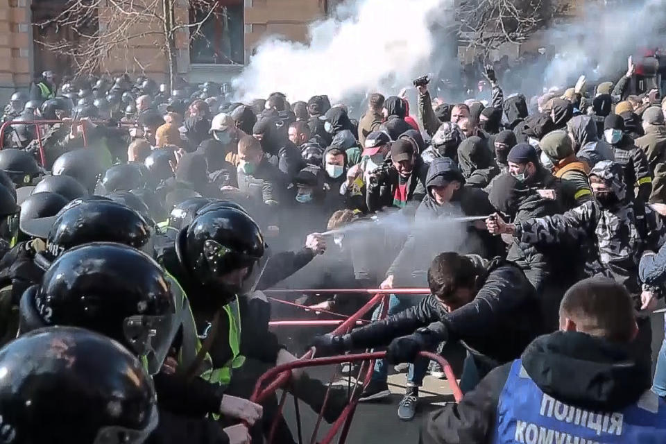 In this image from video provided by the Radio Free Europe/Radio Liberty, far-right demonstrators clash with riot police outside the presidential administration building in Kiev, Ukraine, Saturday, March 9, 2012. Three police officers in Ukraine have been injured in a clash with far-right demonstrators in the capital. The violence occurred outside the presidential administration building in Kiev where several hundred demonstrators had gathered Saturday to call for arrests of top figures in an alleged military corruption scandal. (Radio Free Europe/Radio Liberty via AP)