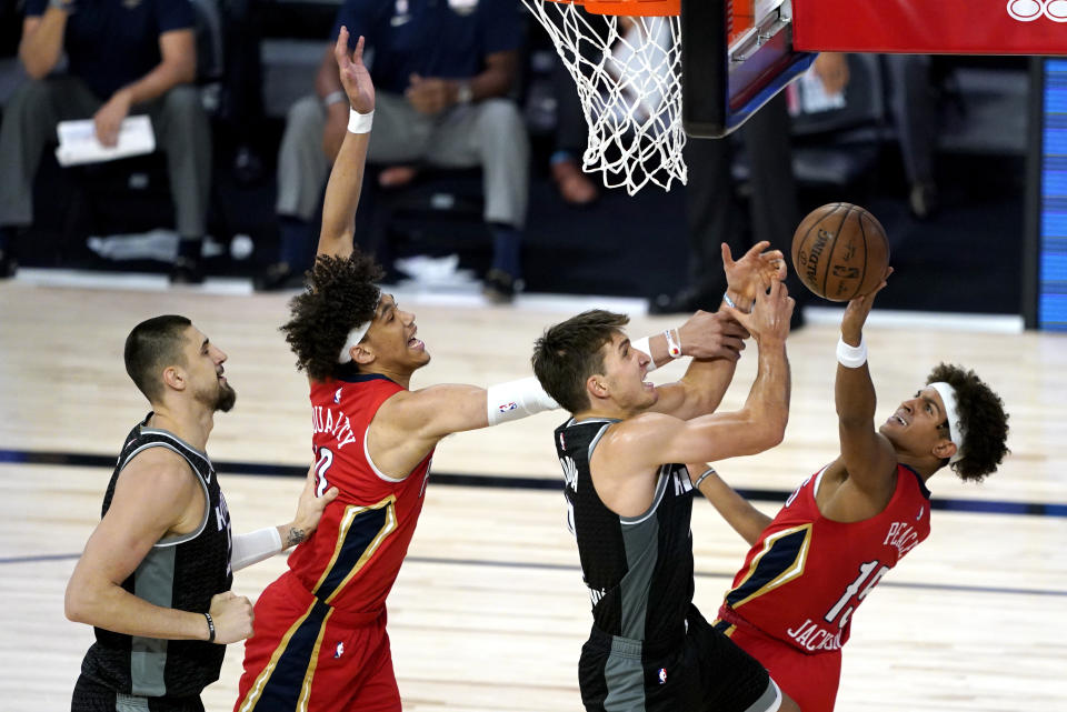 Sacramento Kings' Bogdan Bogdanovic, center right, competes for an offensive rebound against New Orleans Pelicans' Frank Jackson, right, and Pelicans' Jaxson Hayes, center left, as Kings' Alex Len, left, looks on during the second half of an NBA basketball game Thursday, Aug. 6, 2020 in Lake Buena Vista, Fla. (AP Photo/Ashley Landis, Pool)