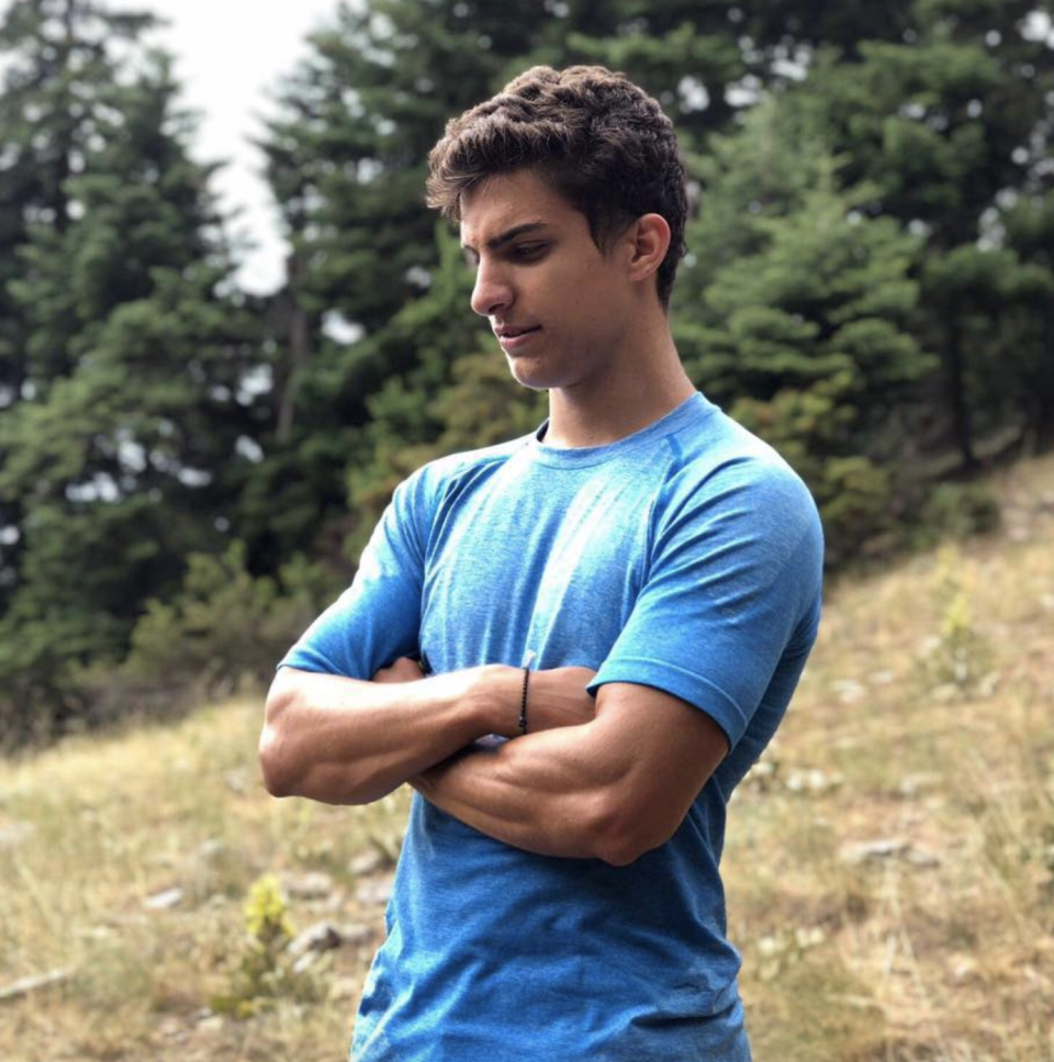 Photo shows Mr Papadimitriou standing with his arms crossed in a field.