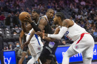 Sacramento Kings guard Terence Davis, left, drives to the basket past Los Angeles Clippers center Serge Ibaka and guard Paul George during the first quarter of an NBA basketball game in Sacramento, Calif., Saturday, Dec. 4, 2021. (AP Photo/Randall Benton)