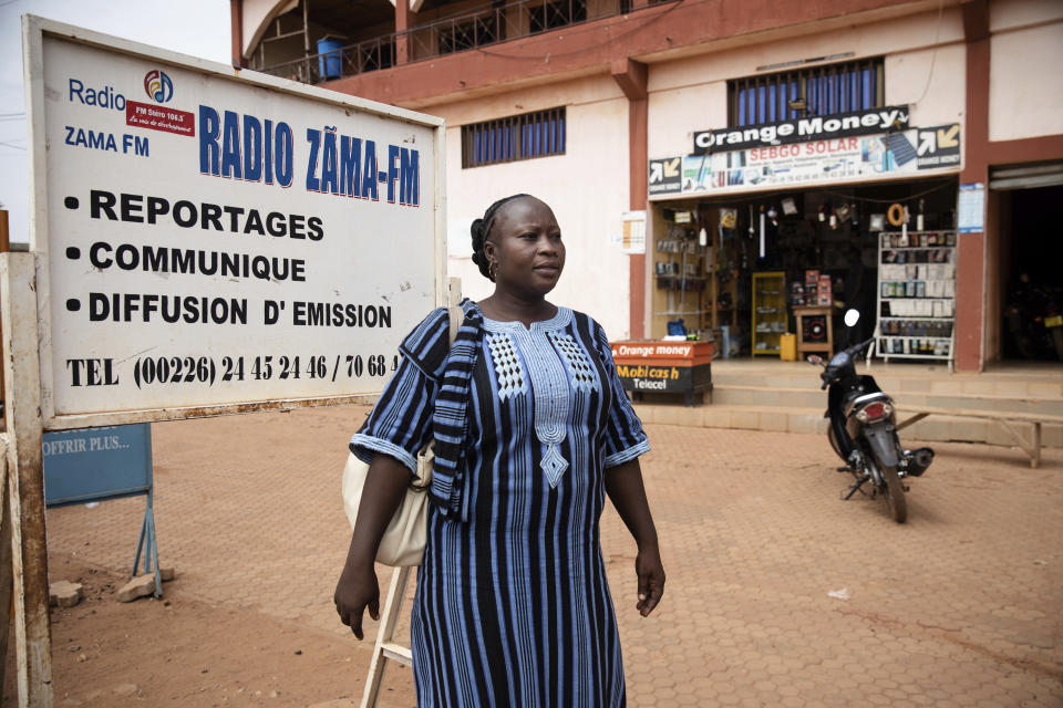 Mariama Sawadogo, 44, poses outside Zama Radio where she works as a radio host in Kaya, Burkina Faso, Monday, Oct. 25, 2021. Sawadogo's voice has become a familiar sound for nearly a million people in her town of Kaya and beyond. In the West African country of Burkina Faso, many feel the government has let them down during the pandemic. Tests, vaccines and messaging often miss many residents, despite a $200 million budget for virus-response efforts. In a region where women are responsible for family work and community relationships, they’ve stepped up to fill in gaps. (AP Photo/Sophie Garcia)