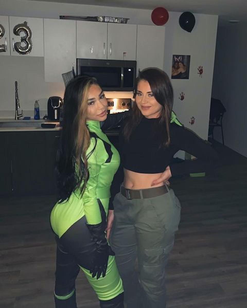 A woman dressed up as Shego poses next to a women dressed as Kim Possible.