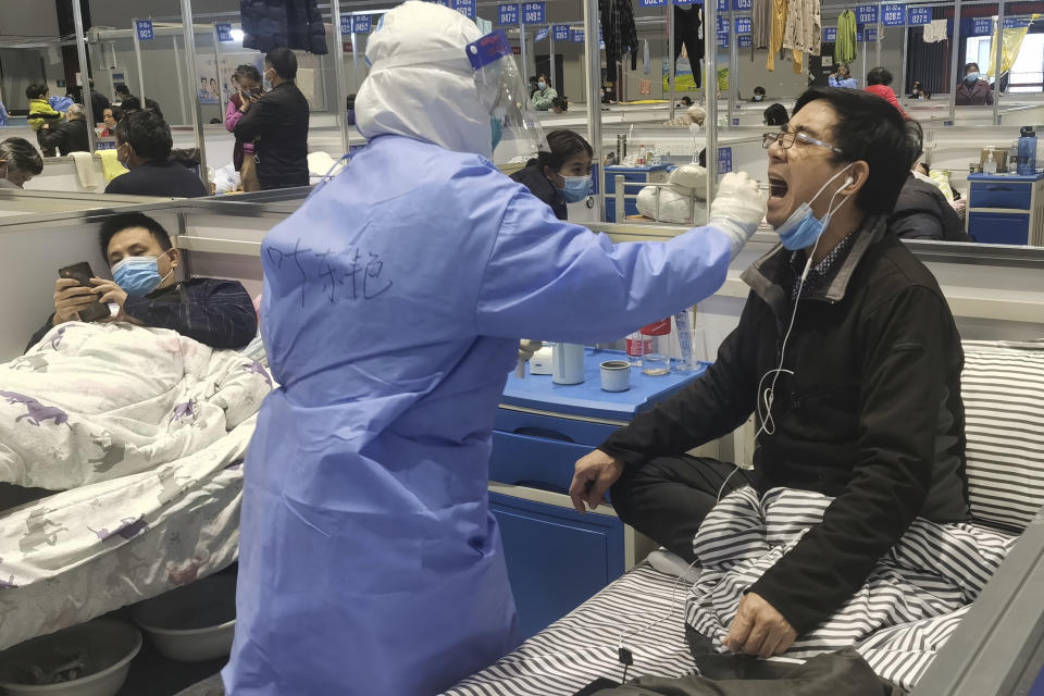 Residents get tested during their stay at a temporary hospital converted from the National Exhibition and Convention Center to quarantine COVID-positive people in Shanghai, China on April 18, 2022. Interviews with family members of people testing positive for COVID-19, a phone call with a government health official and an independent tally raise questions about how Shanghai calculates virus cases and deaths, almost certainly resulting in a marked undercount. (Chinatopix via AP)