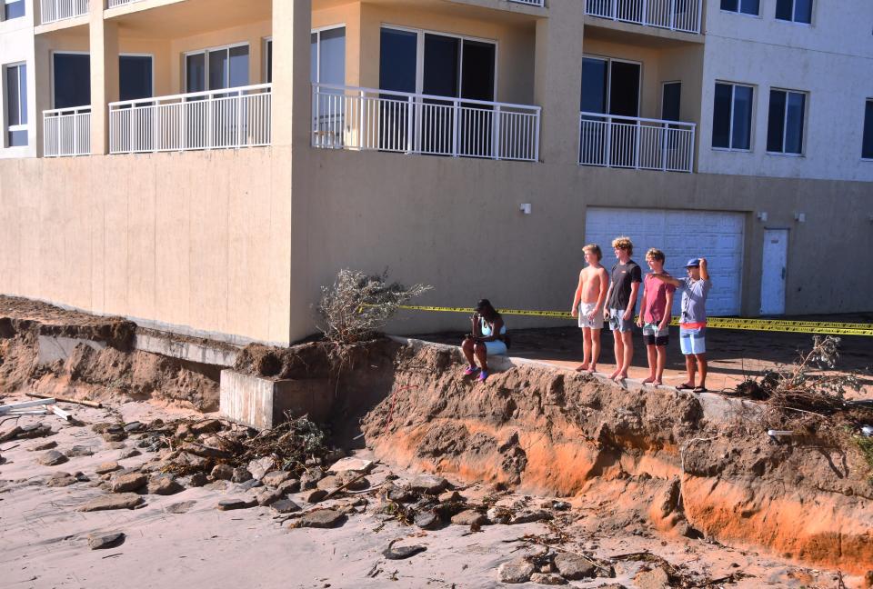 Beach spectators gather after Tropical Storm Nicole last year to check out the beach erosion near the Oceana Oceanfront Condominium north tower in Satellite Beach.