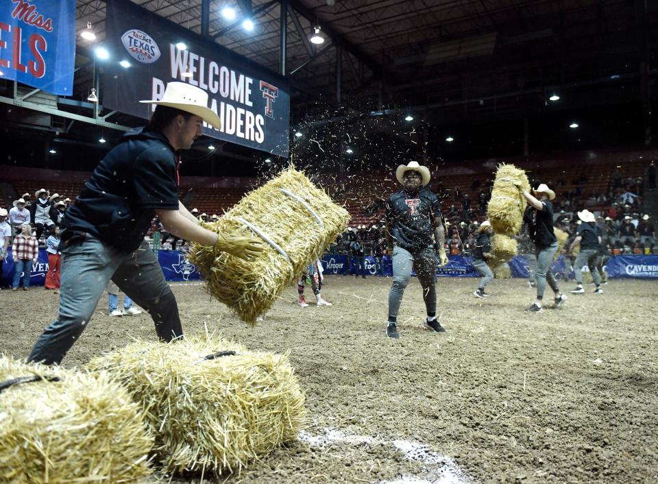 A team of Texas Tech players competes in hay-bale stacking during the Rodeo Bowl competition on Monday night in Houston. Tech won five of seven events in the competition against Mississippi.