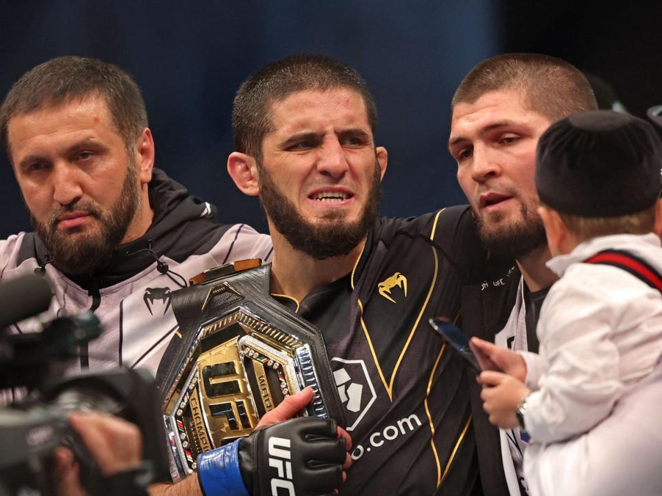 Makhachev (center) celebrates with Nurmagomedov (center right) after becoming champion (AFP via Getty Images)