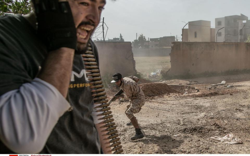  Fighters of the UN-backed Government of National Accord (GNA) take cover during clashes with Libyan National Army (LNA) at Salah Al-Din frontline in Tripoli - Shutterstock