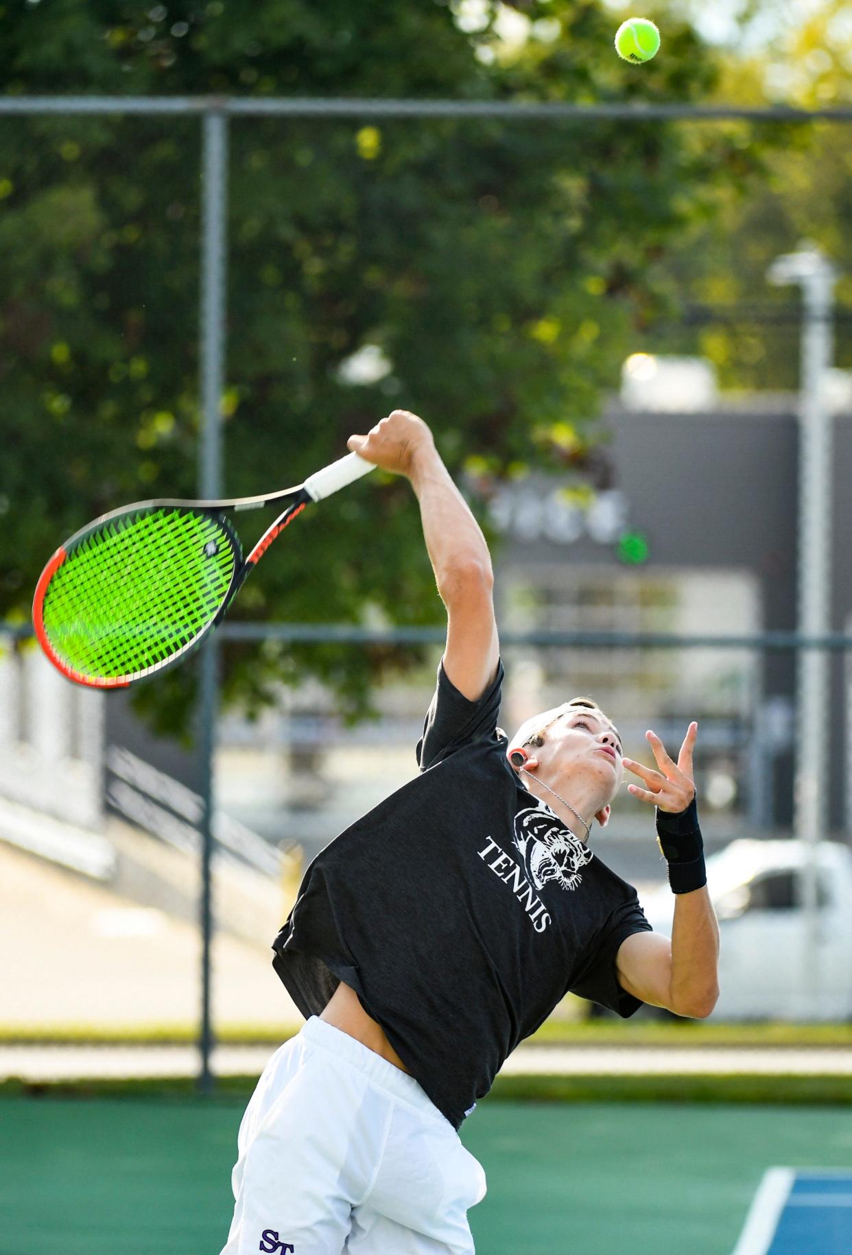 Bloomington South’s Michael Asplund serves the ball during his No. 1 singles match against Bloomington North’s Nick Shirley during the Bloomington North-Bloomington South tennis match at South in 2021.