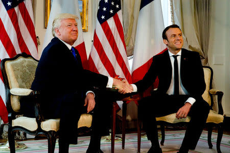 U.S. President Donald Trump (L) shakes hands with French President Emmanuel Macron before a working lunch ahead of a NATO Summit in Brussels, Belgium, May 25, 2017. REUTERS/Peter Dejong/Pool