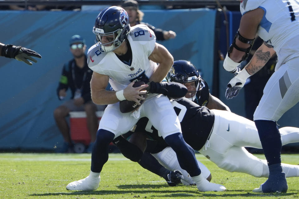 Tennessee Titans quarterback Will Levis (8) is sacked by Jacksonville Jaguars linebacker Foyesade Oluokun, and defensive end Roy Robertson-Harris, right, during the first half of an NFL football game, Sunday, Nov. 19, 2023, in Jacksonville, Fla. (AP Photo/John Raoux)
