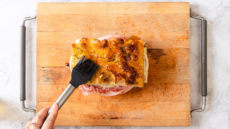 Brushing focaccia sandwich with oil