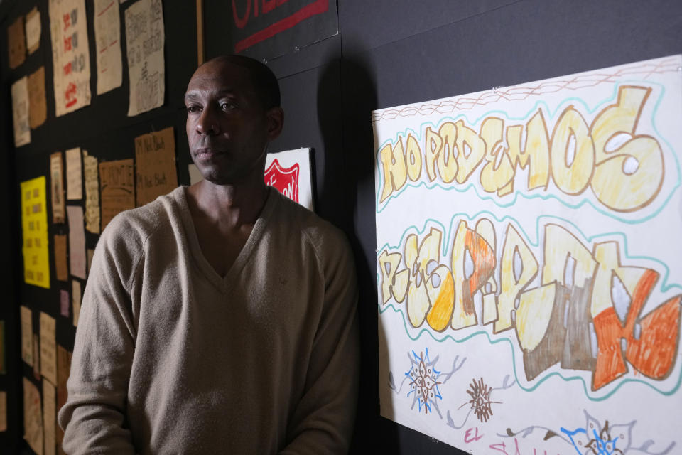 Rashad Shabazz, an Arizona State University professor, pauses at the exhibit "Twin Flames: The George Floyd Uprising from Minneapolis to Phoenix," Friday, Jan. 12, 2024, in Tempe, Ariz. For months after George Floyd was killed by police in May 2020, people from around the world traveled to the site of his murder in Minneapolis and left signs, paintings and poems to memorialize the man whose death reignited a movement against systemic racism. Now hundreds of those artifacts are being displayed at an exhibit at the Arizona State University Art Museum. (AP Photo/Ross D. Franklin)