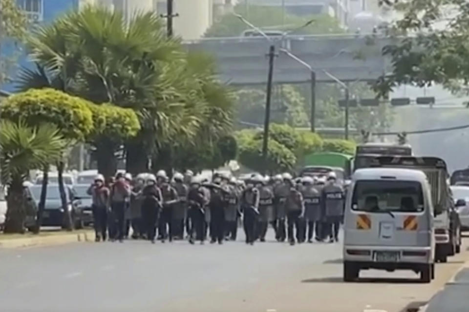 In this image made from video, police in riot gear move in at anti-coup protesters gathered in Yangon, Myanmar, Saturday, Feb. 27, 2021. Myanmar police on Saturday moved to clear anti-coup protesters from the streets of the country's biggest city Yangon. (AP Photo)